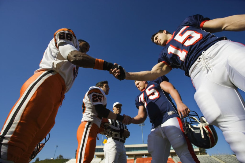 Football players shaking hands before a game.