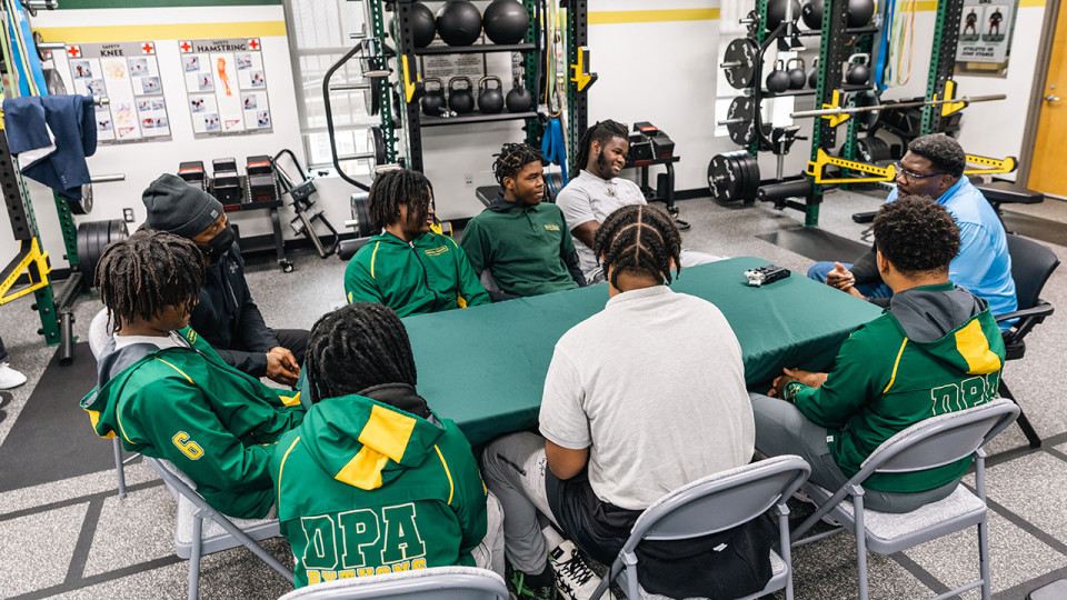 Athletes in graduation caps and gowns
